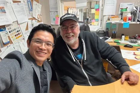 Justin and Ron Jones smiling in a selfie at Ron’s office desk